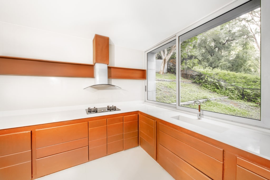 Designer kitchen with teak cabinetry and garden view