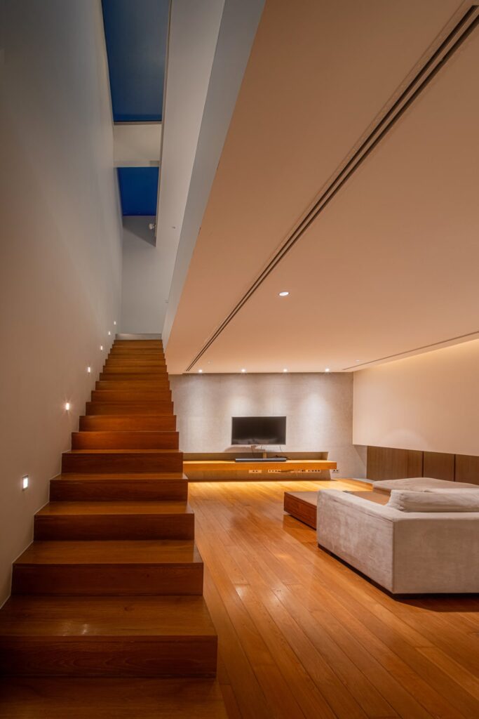Teak staircase with skylight and minimalist lounge