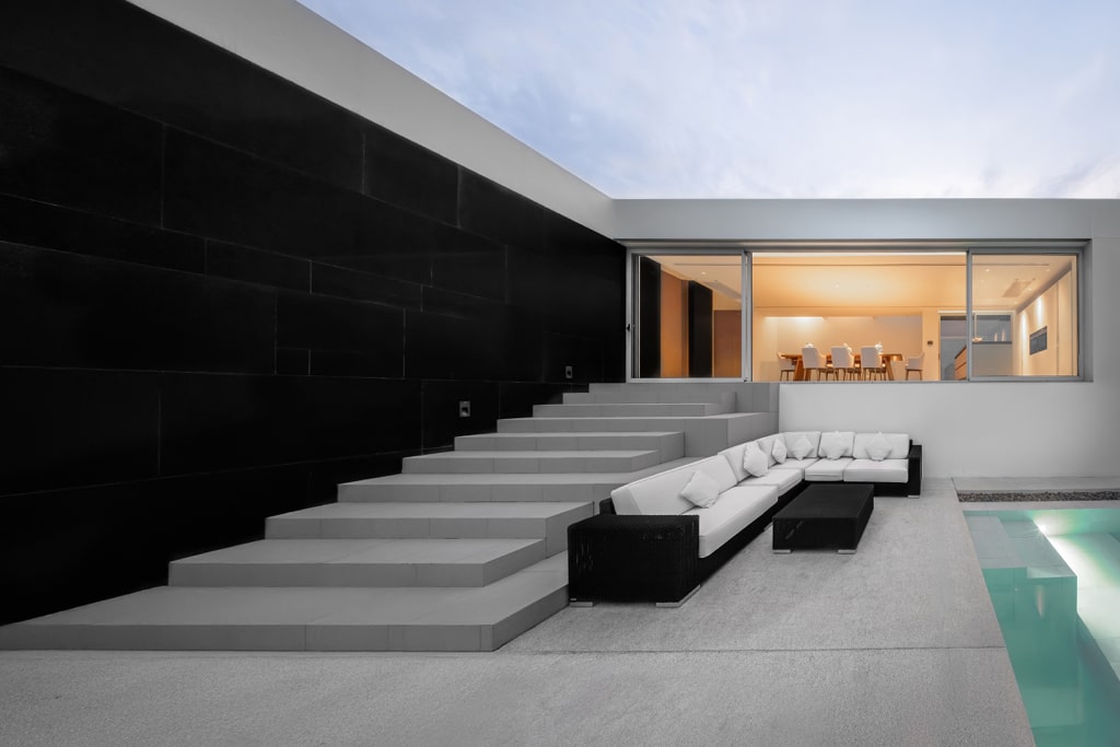 Outdoor lounge area with black stone wall and pool