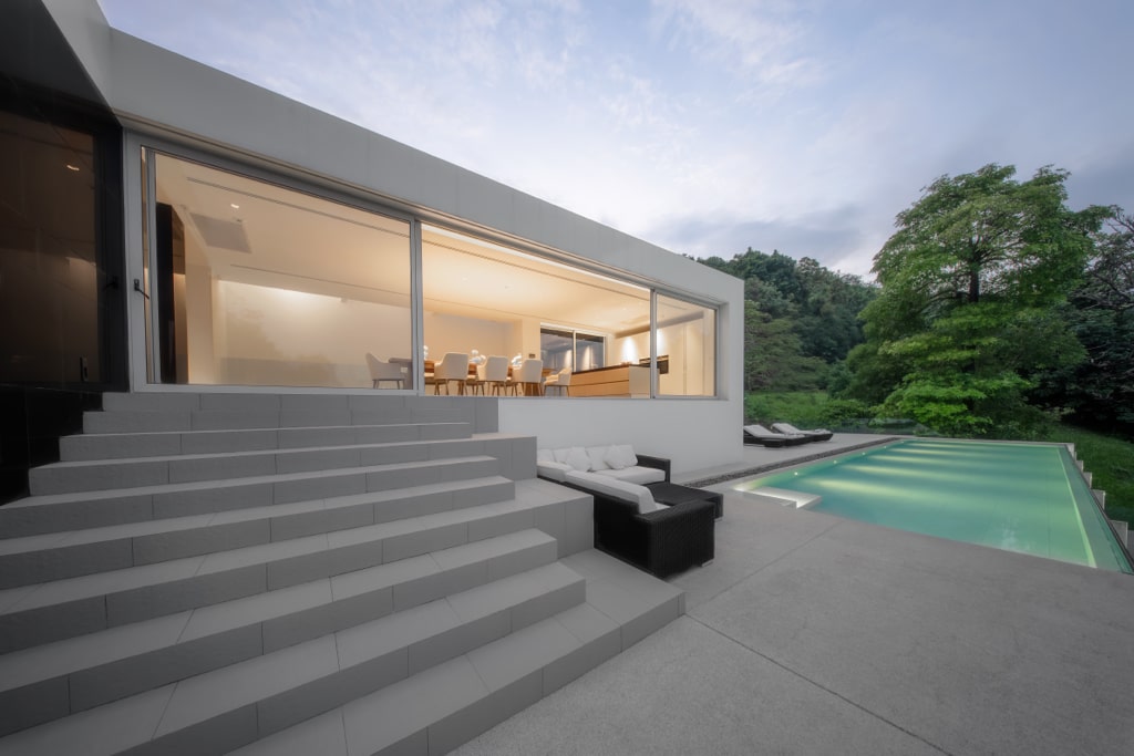 Modern terrace with concrete steps and illuminated pool