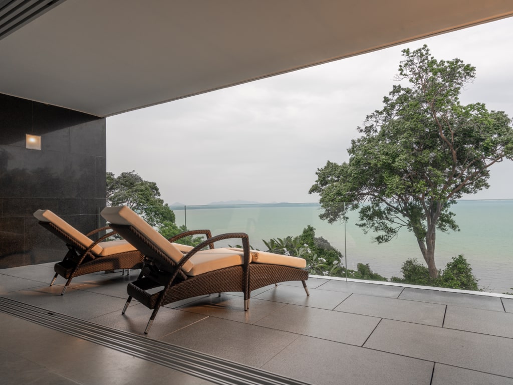 Private terrace with rattan loungers and ocean panorama
