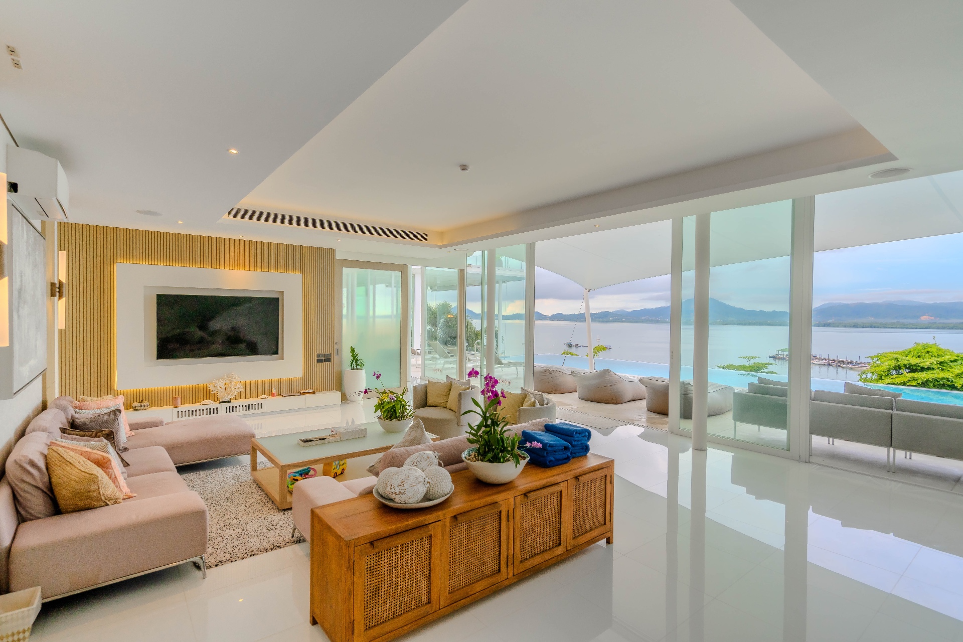 Open-plan living room with pool and sea views