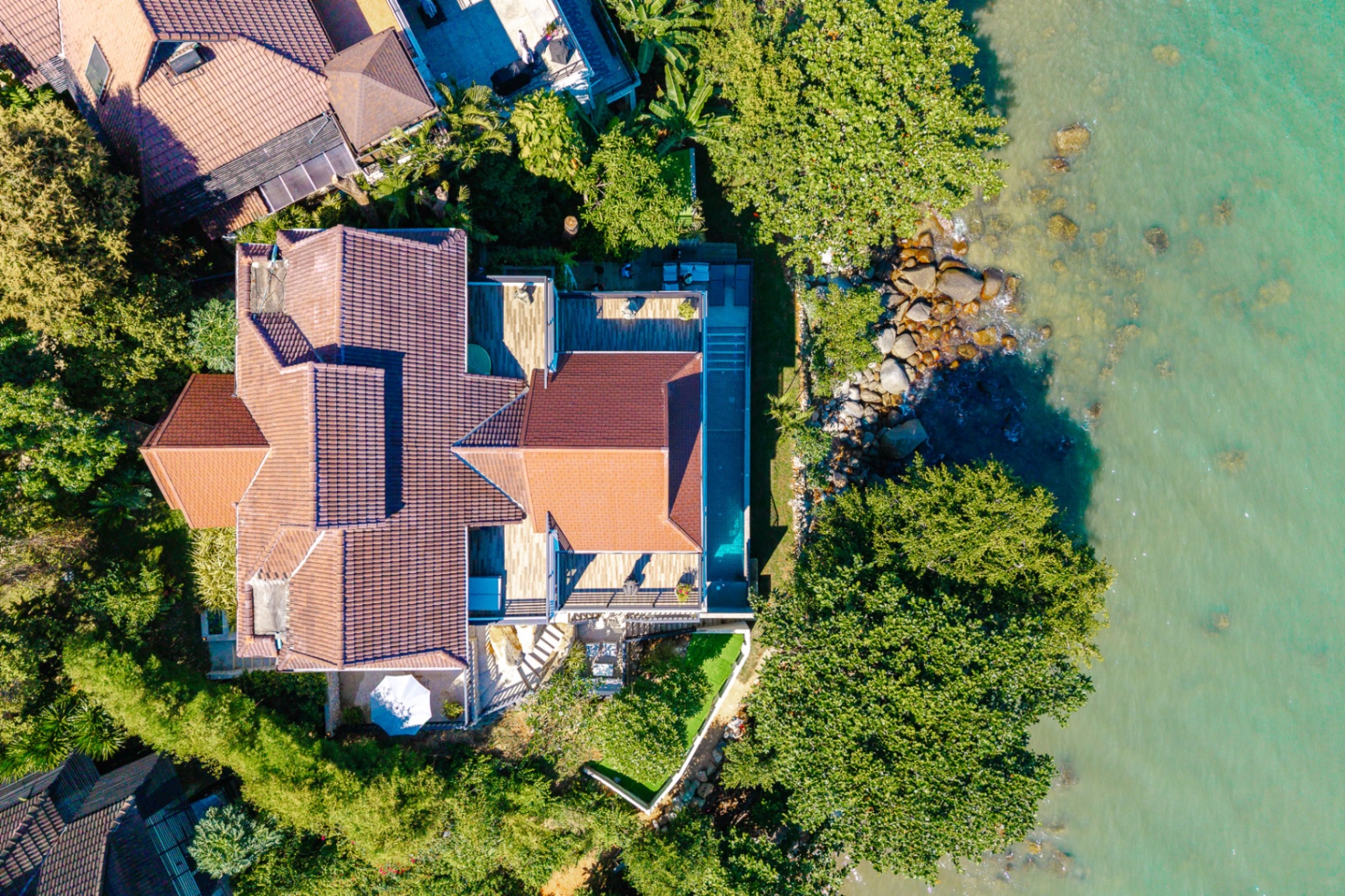 Aerial top-down view of villa with pool and ocean