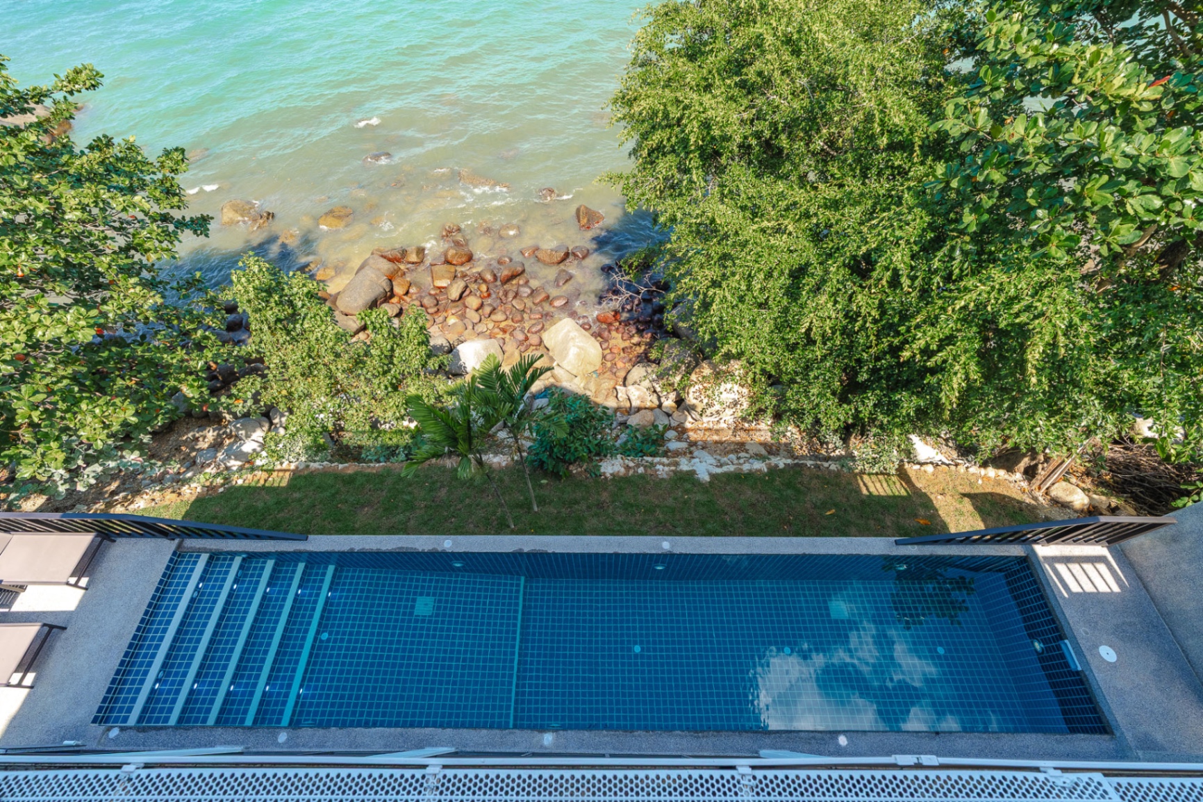Pool top-down view with ocean rocks and garden