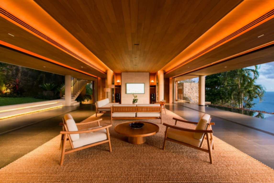 Open-air living pavilion with teak ceiling at evening