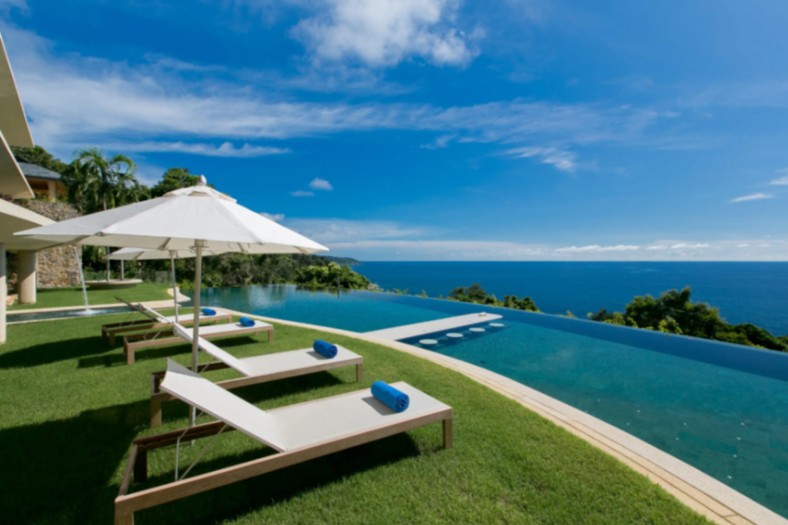 Pool loungers with parasols and ocean panorama