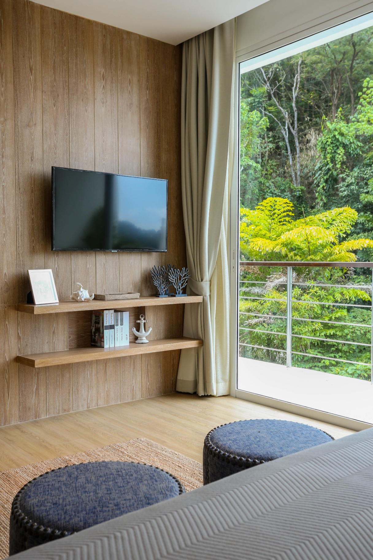 Bedroom with wall-mounted TV and jungle view balcony