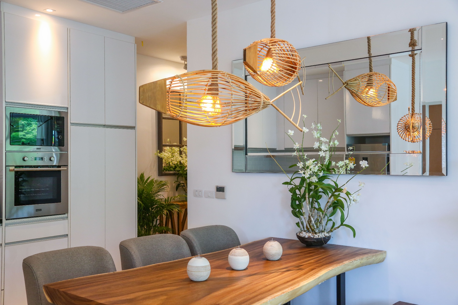 Dining area with mirror and designer pendant lights