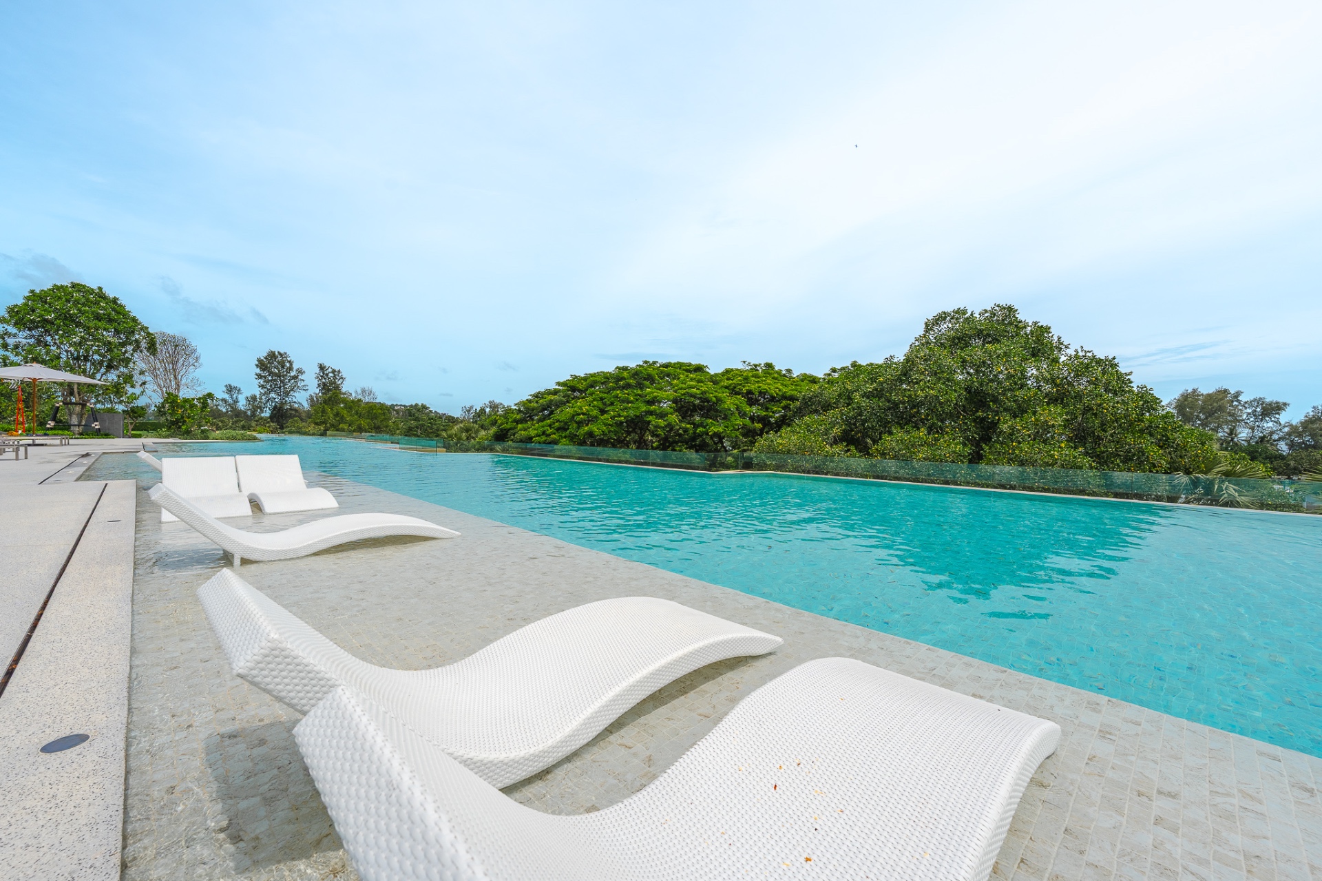 Poolside with white wicker loungers