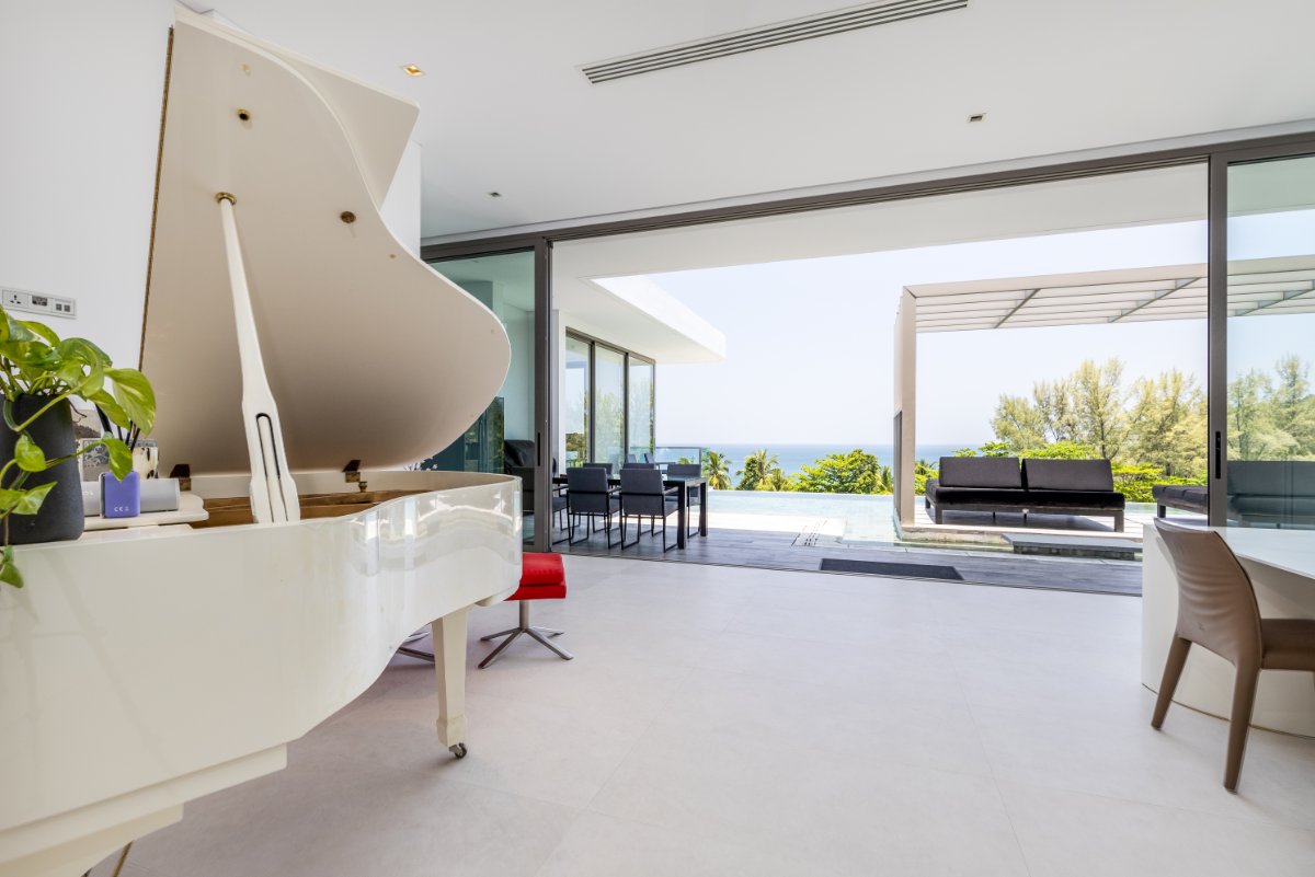 White grand piano with terrace and ocean backdrop