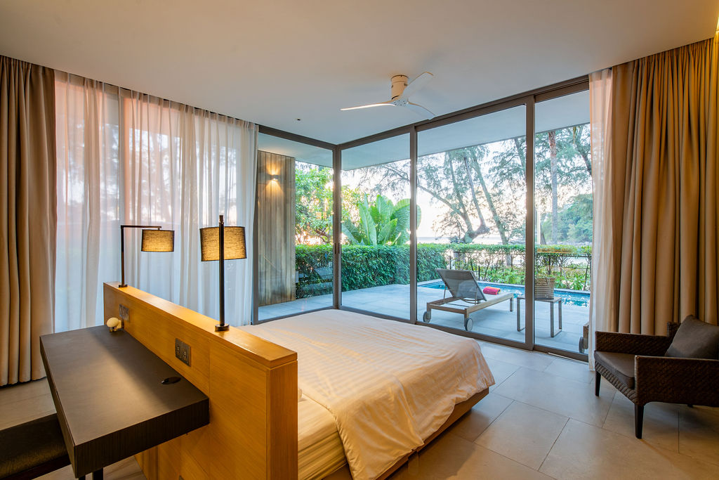 Bedroom with floor-to-ceiling glass and pool views