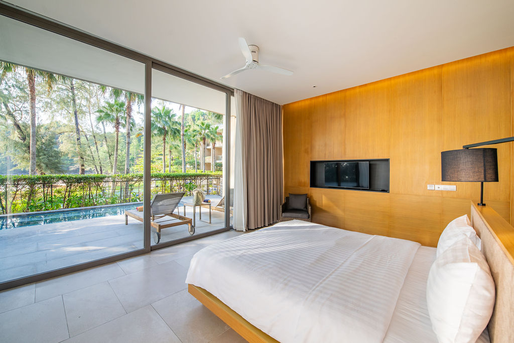 Bedroom with sliding glass doors opening to pool
