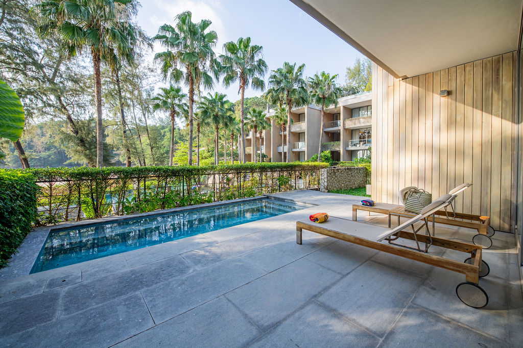Pool terrace with sun lounger surrounded by palms