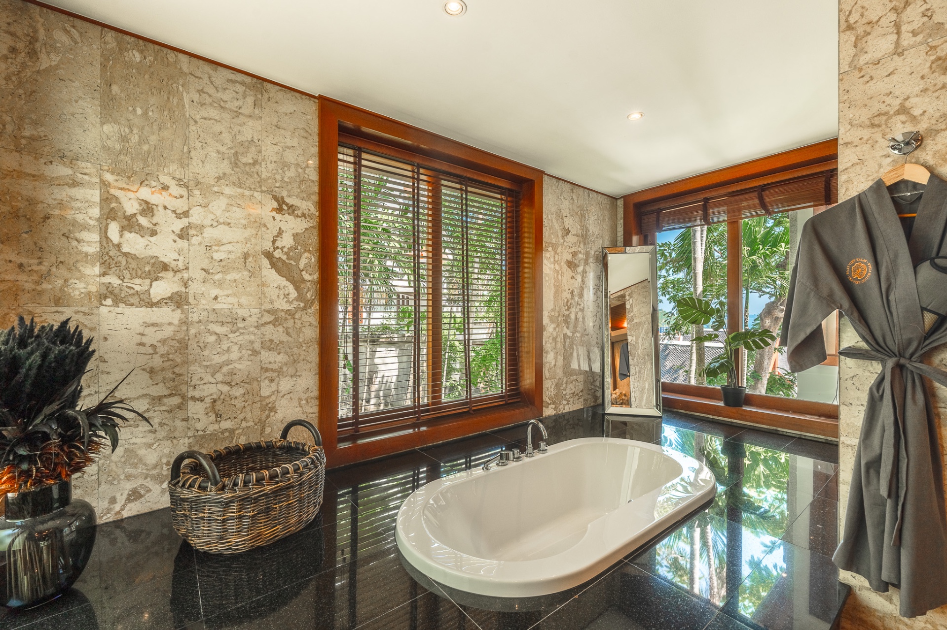Freestanding bathtub with garden views and marble walls