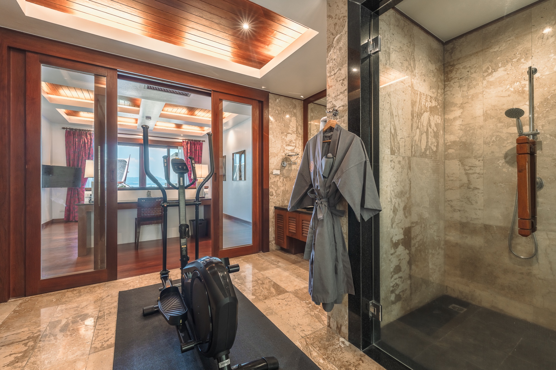 Private gym with cross-trainer and marble shower