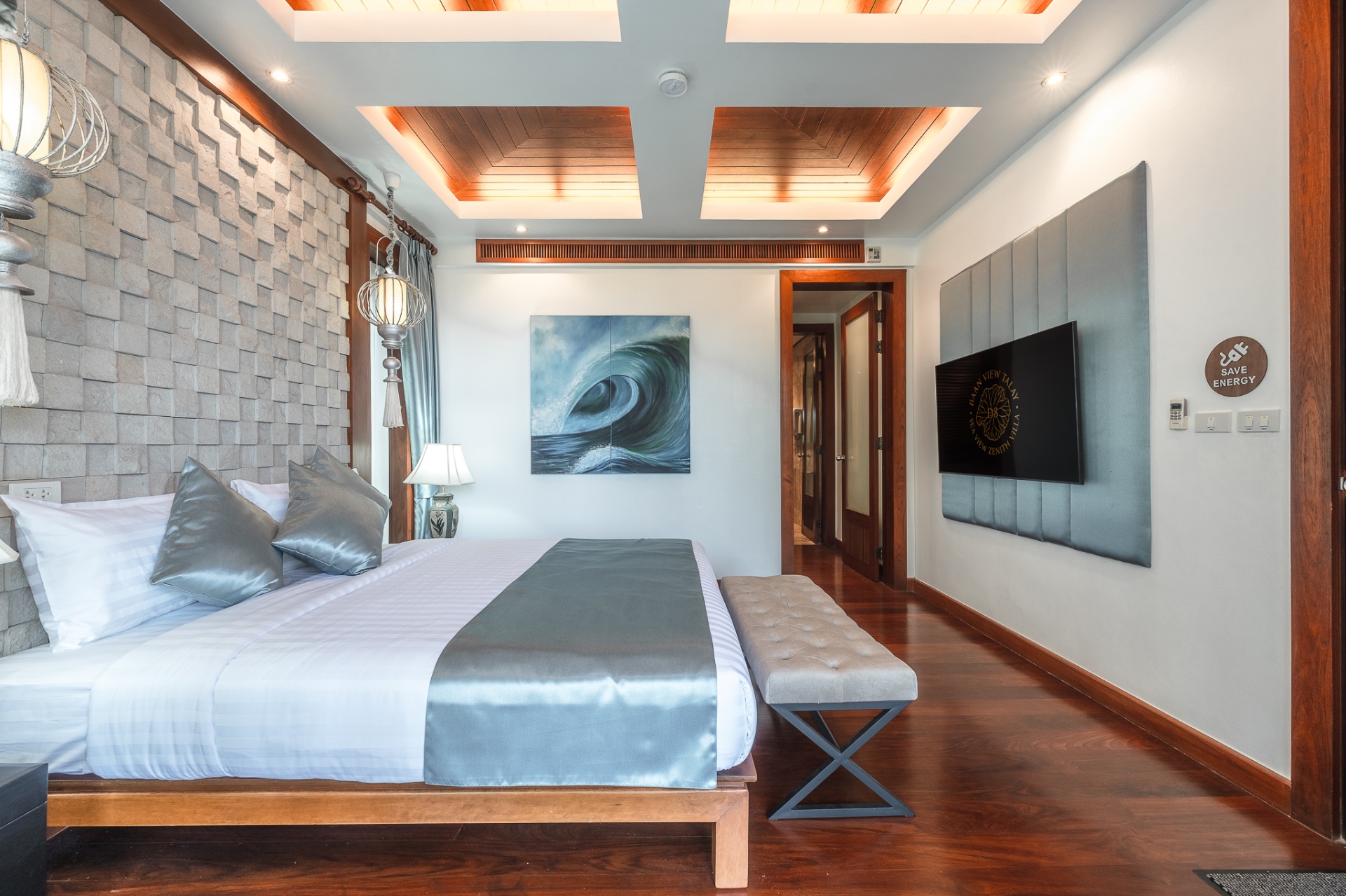 Master bedroom with wall-mounted TV and stone accent wall