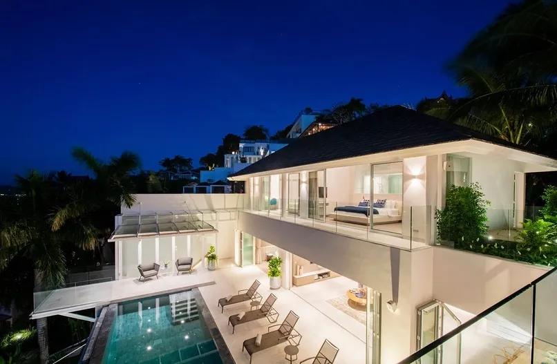 Aerial night view of illuminated villa and pool