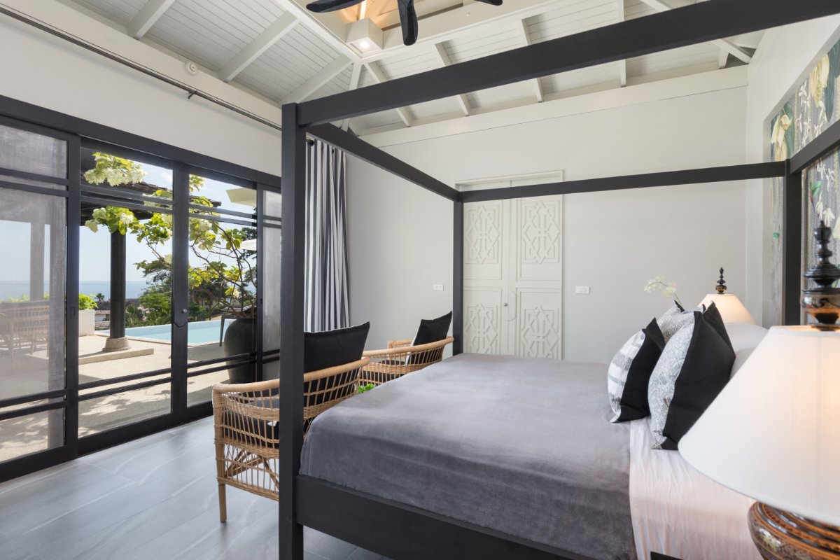 Master bedroom with four-poster bed and pool view