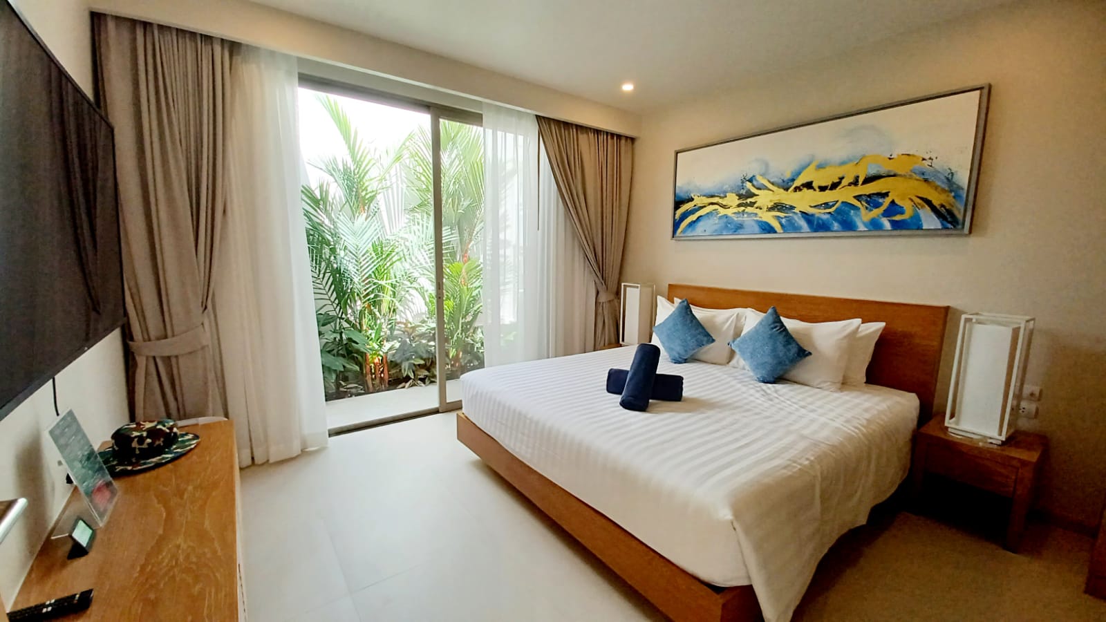 Guest bedroom with garden views and tropical art